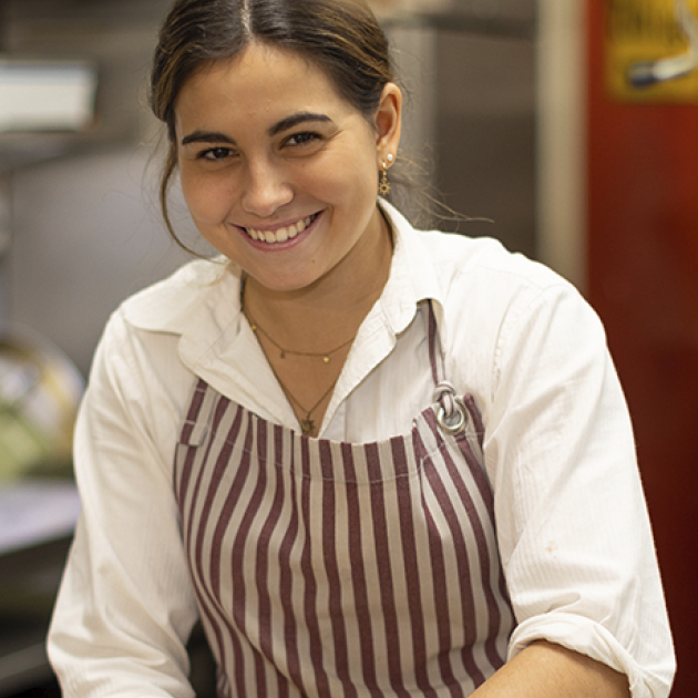 Öl wird über Pinienkerne und Parmesan gegossen