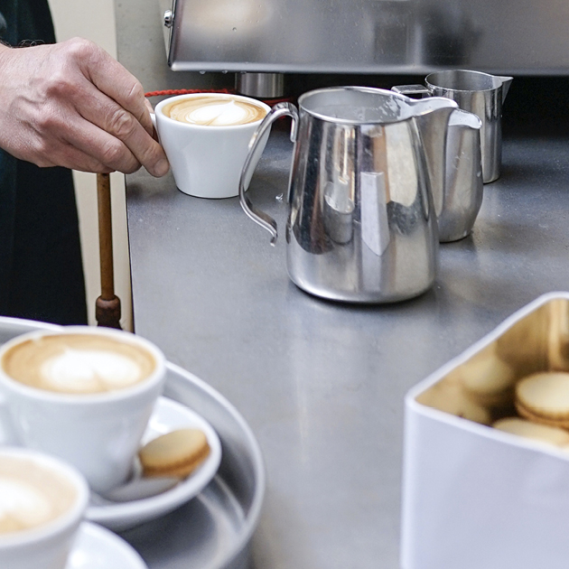 Öl wird über Pinienkerne und Parmesan gegossen