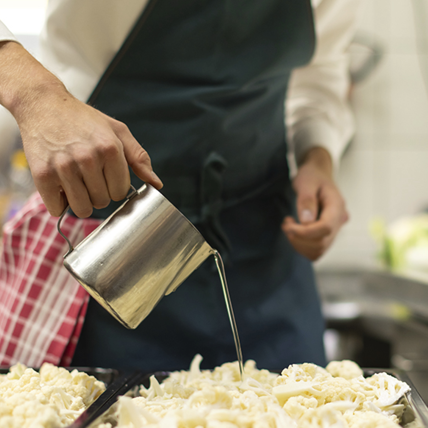 Öl wird über Blumenkohl gegossen