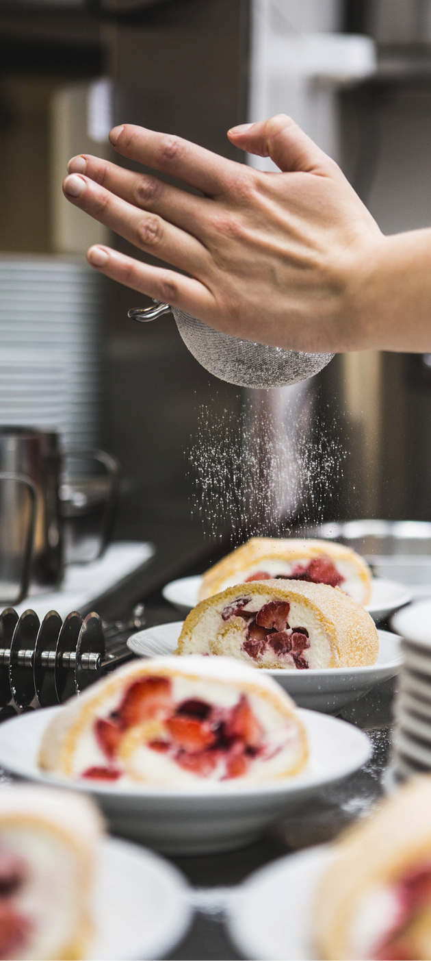 Erdbeerrolle bekommt einen Puderzuckerüberzug