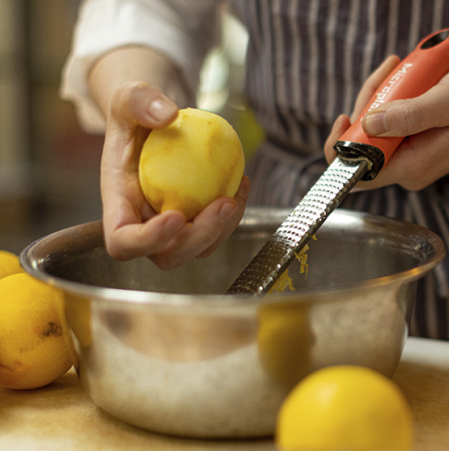 Öl wird über Pinienkerne und Parmesan gegossen